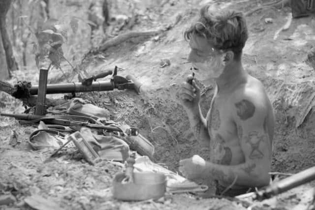 An infantryman shaving in his slit trench, 12 April 1945.