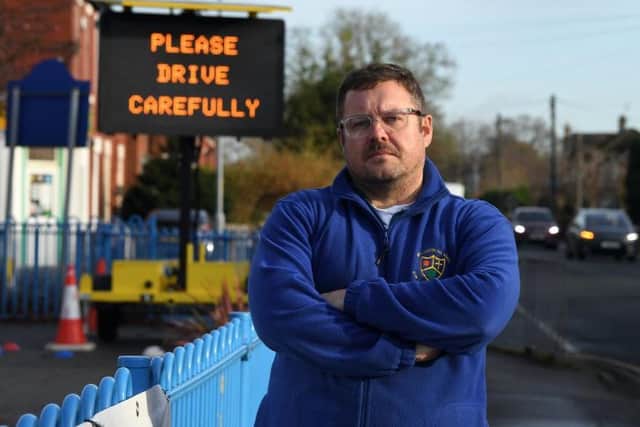 Mr Maloney with the speed awareness sign in his playground, near the site where Lewis Turner was killed.