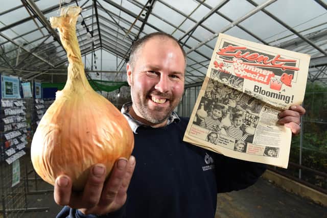 Andrew Redmayne, fifth generation in the business, pictured with one of the Mammoth onions and a cutting featuring him when he was a youngster  at the nursery.          Photo: Neil Cross
