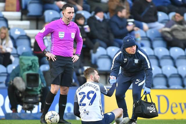 Tom Barkhuizen gets attention from PNE physio Matt Jackson as referee Chris Kavanagh watches on