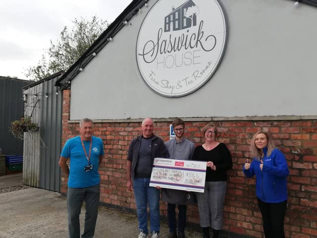 Joanne Rossall, from Kirkham, presents Rosemere Cancer Foundation’s Yvonne Stott (far right) and Blue Skies volunteer ambassador Phil Robinson (far left) with her donation watched by Peter and Harry