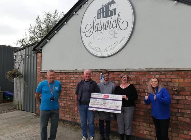 Joanne Rossall, from Kirkham, presents Rosemere Cancer Foundation’s Yvonne Stott (far right) and Blue Skies volunteer ambassador Phil Robinson (far left) with her donation watched by Peter and Harry