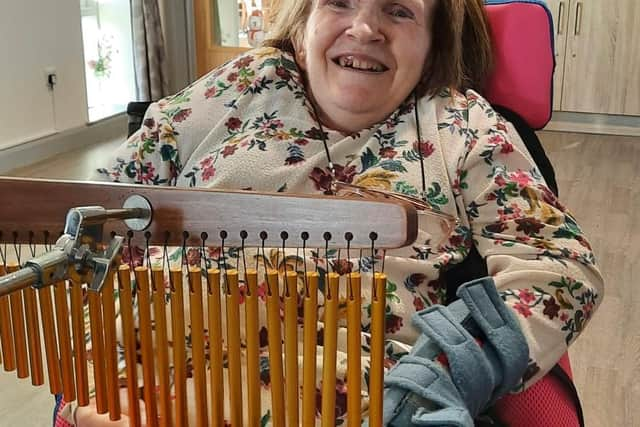 Karen  Masterson pictured playing wind chimes