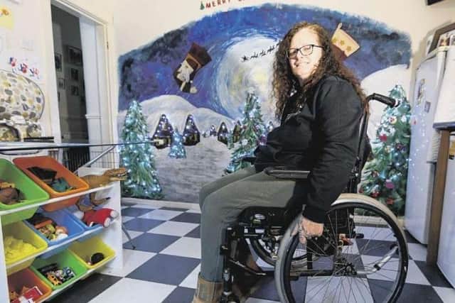 Kirsty Rea, 48, sat in her wheelchair in front of the artwork she painted by hand