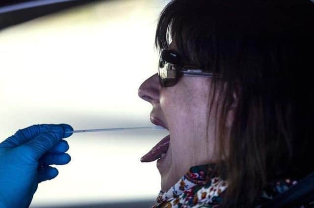 A woman undergoes a PCR throat swab. Pic: AP/Manu Fernandez