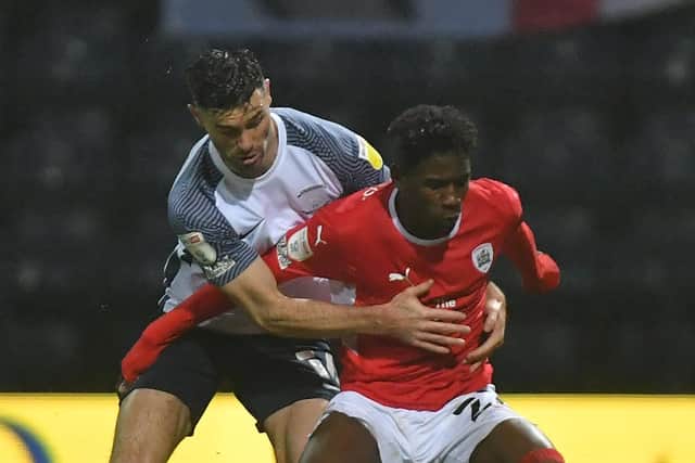 Andrew Hughes challenges Barnsley's Clarke Oduor