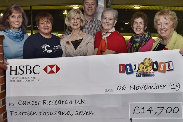 Jackie Perkins, Jo Marriott, Maggie Perkins, Richard Perkins, Annette Beeton,  Judith Wojtowicz and Audrey Scotney  at pres of cheque for £14,700 from the Peterborough Greyhound Stadium to Cancer Research UK .