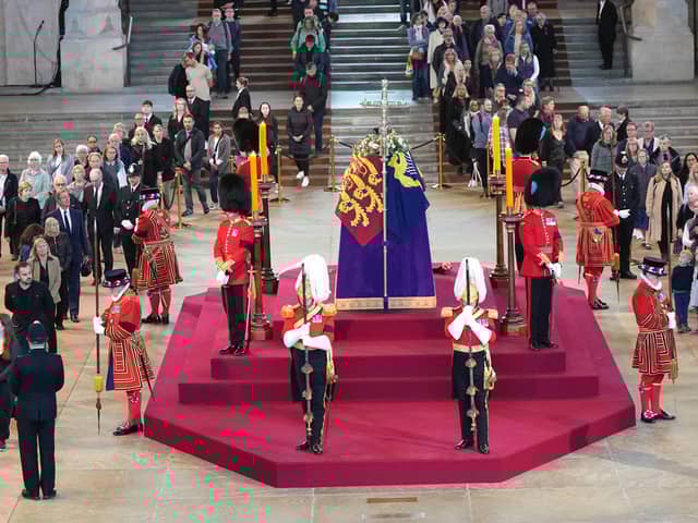 Members of the public file past the coffin of Queen Elizabeth II, draped in the Royal Standard with the Imperial State Crown and the Sovereign's orb and sceptre, lying in state on the catafalque in Westminster Hall, at the Palace of Westminster, London, ahead of her funeral on Monday. Picture: Yui Mok/PA Wire