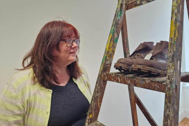 Artist Fiona Hornby examines a pair of 70 year old walking boots at the 'Special Shoes' exhibition currently running  at The Salon in lower St James' Street, Burnley, funded by the Heritage Action Zone (HAZ)