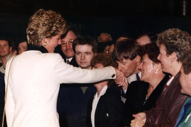 Leyland DAF area manager Gerry Smith, 46, leans forward to kiss Princess Diana on the hand during her visit to Lancashire in 1993