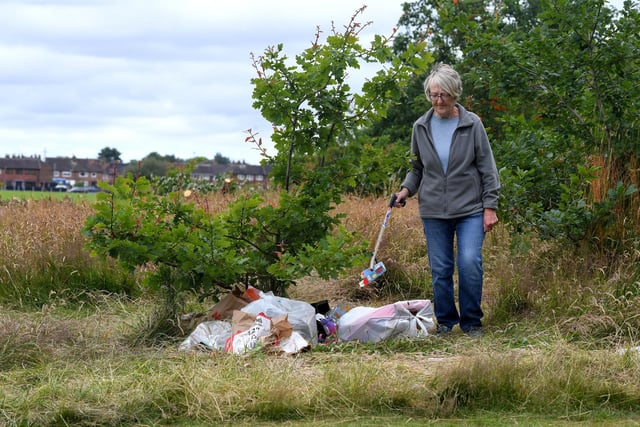 Kath Wootton cleaning up the mess left behind by a group of travellers.