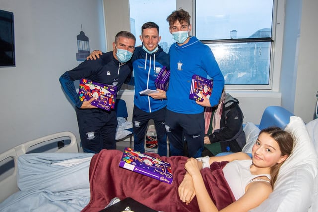 Gaffer Ryan Lowe and players with a young patient