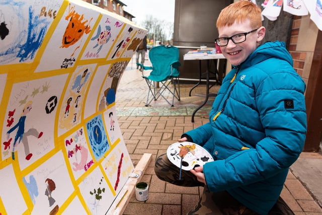 Billy Rowbottom (9) paints on a bench