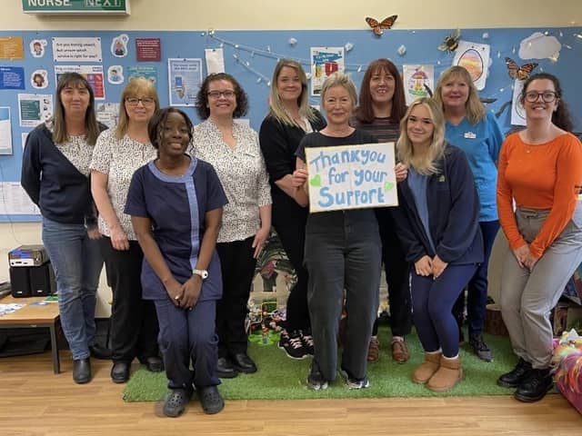 Dr. Ann Robinson (holding the placard) and the Withnell Health Centre team show their gratitude to patients