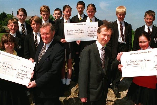 Chairman of the North Lancashire Health Authority Ron Parkinson (centre left) and consultant in public health medicine Dr Anthony Sudell, present prizes to local Preston schools who beat other schools in Lancashire at a Science Week competition. Pictured receiving their prizes are pupils from St Cecelia High School, Broughton High School and Ashton High School