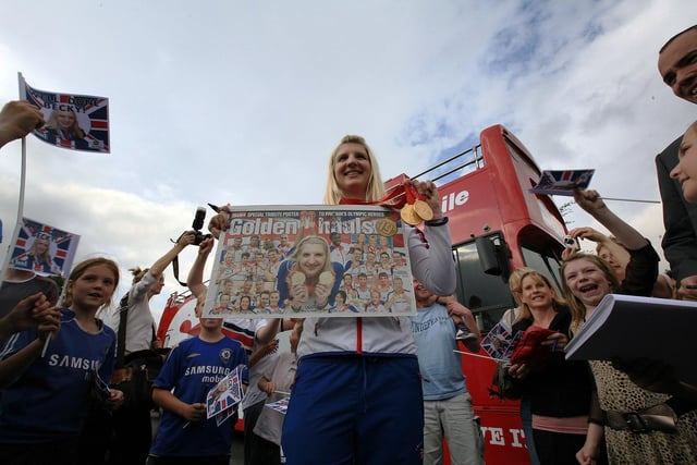 Becky holds up a newspaper spread hailing the success of Team GB. Her two medals contributed to an overall medal haul of 19 golds in Beijing for Team GB.
