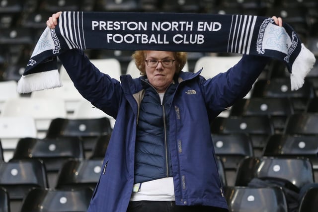 A PNE fan proudly holds their scarf aloft.