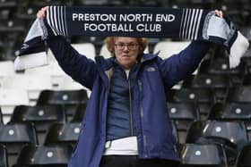 A PNE fan proudly holds their scarf aloft.
