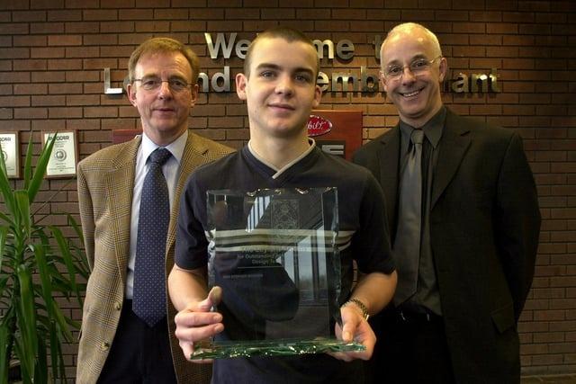 Christ the King School pupil Stephen Worden receiving a design award from Leyland Truck's managing director Stuart Heyes, accompanied by headteacher Gus Van Cavwelaert in 2003