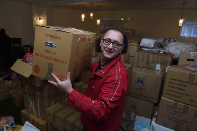 Tomasz Soloducha sorting donations he and his wife have helped collect for Ukrainian refugees in Poland