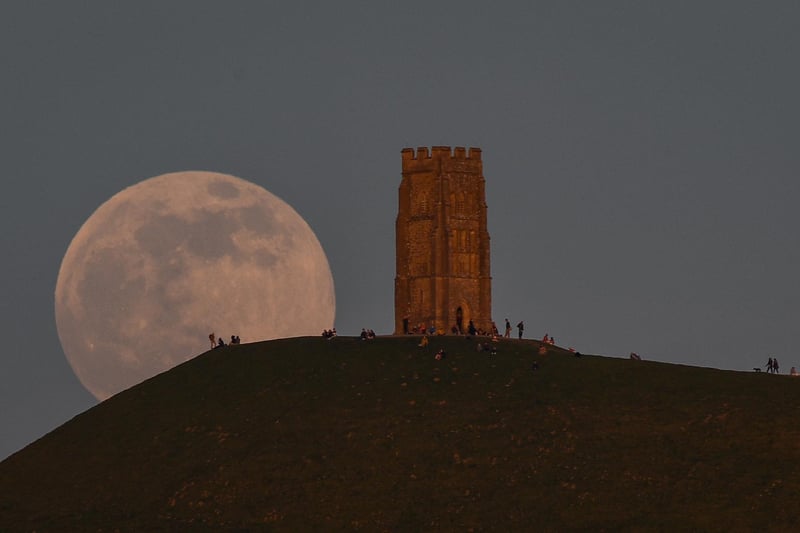 The full moon rises behind Glastonbury Tor (Photo by Finnbarr Webster/Getty Images)