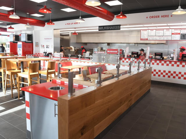 The fast food joint has a chic diner's style decoration with red and white tiles and minimal furniture.