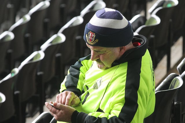 A PNE fan checks his phone at Derby