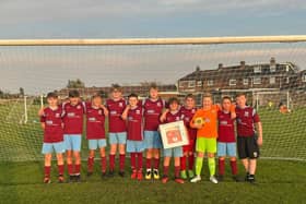 Ormskirk West End FC players with the defibrillator donated by Taylor Wimpey