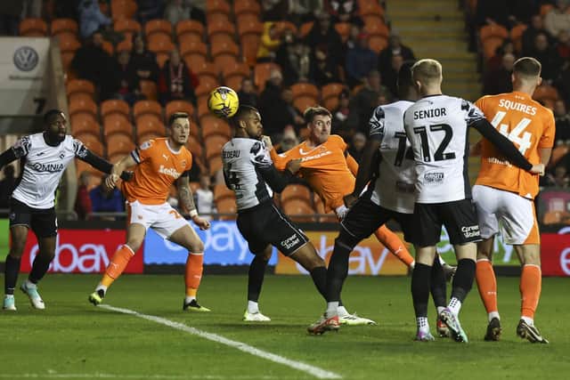 Blackpool’s Jake Beesley (centre) scores the opening goal despite the attentions of Morecambe’s Jacob Bedeau (photo: Lee Parker/CameraSport)
