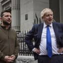 In this image provided by the Ukrainian Presidential Press Office, Ukrainian President Volodymyr Zelenskyy, left, and Britain's Prime Minister Boris Johnson talk during their walk in downtown Kyiv, Ukraine