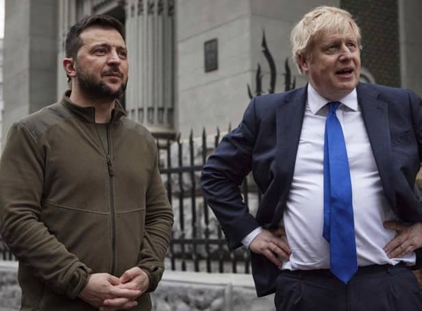In this image provided by the Ukrainian Presidential Press Office, Ukrainian President Volodymyr Zelenskyy, left, and Britain's Prime Minister Boris Johnson talk during their walk in downtown Kyiv, Ukraine