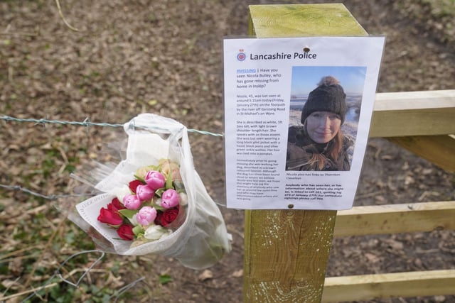 Flowers left next to a 'missing' sign close to where she was last spotted walking her dog on a footpath near the River Wyre. Picture date: Saturday February 4, 2023.