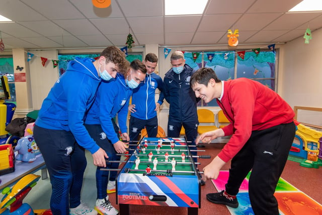 Players Ryan Ledson, Greg Cunningham and Alan Browne take one a patient at table football - under the watchful eye of PNE manager Ryan Lowe
