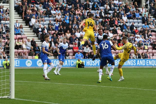 Preston North End's Ben Woodburn has this shot blocked by Wigan Athletic's Curtis Tilt.