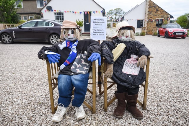 Two scarecrows bemoan the weather.