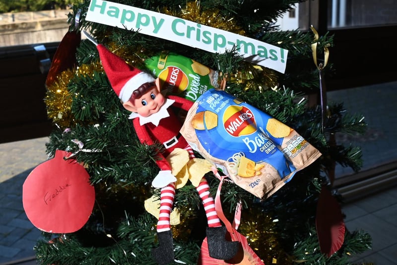 The Elf on the Shelf enjoying some crisps while lounging on one of the trees.