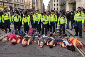 Just Stop Oil supporters lie on the ground in London road blockades.