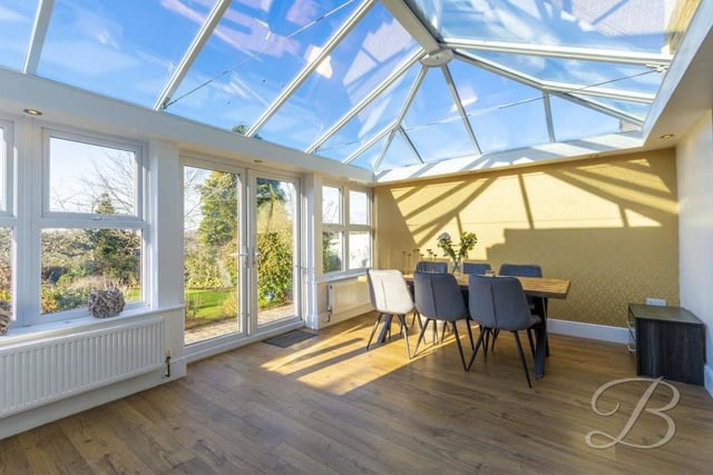 This impressive conservatory, an addition to the property, doubles up as a dining room, overlooking the garden.