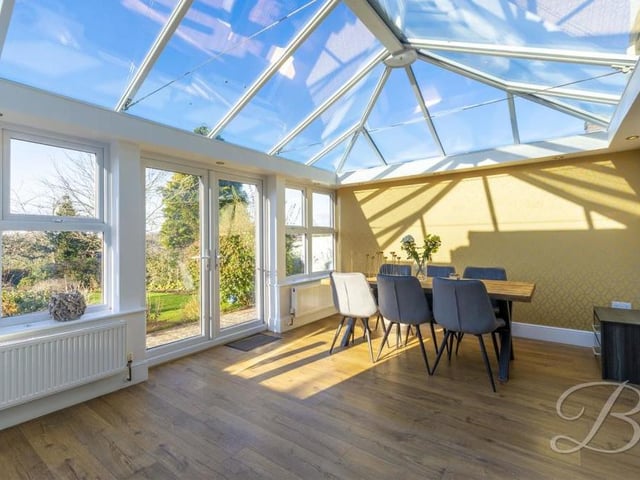 This impressive conservatory, an addition to the property, doubles up as a dining room, overlooking the garden.