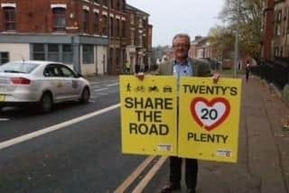 Cllr Rupert Swarbrick holding the new signage