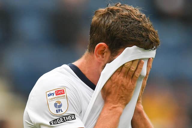 PNE striker Ched Evans pulls his shirt over his head.