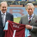 Then Prince Charles poses with Burnley Chairman Barry Kilby (L) while holding a Burnley football shirt as meets representatives of Burnley Football Club at Turf Moor, the Burnley football club ground on February 5, 2010 in Burnley, England.  (Photo by Arthur Edwards/WPA Pool/Getty Images)