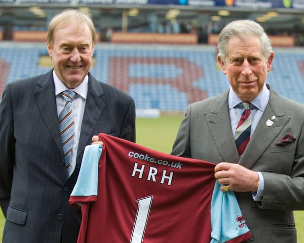 Then Prince Charles poses with Burnley Chairman Barry Kilby (L) while holding a Burnley football shirt as meets representatives of Burnley Football Club at Turf Moor, the Burnley football club ground on February 5, 2010 in Burnley, England.  (Photo by Arthur Edwards/WPA Pool/Getty Images)