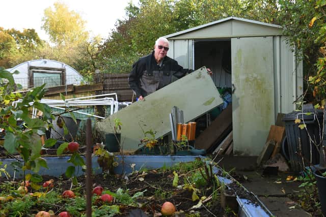 Steve Shuttleworth tries to repair his damaged shed door after it was mindlessly ripped off