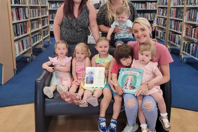 Childminders from Leyland - Sophie Foster (back left), Kayleigh Beattie (back right), Sophie Mashiter (front) with children they mind and the Queen's Letter thanking them for their colourings