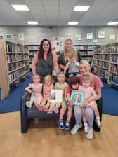 Childminders from Leyland - Sophie Foster (back left), Kayleigh Beattie (back right), Sophie Mashiter (front) with children they mind and the Queen's Letter thanking them for their colourings