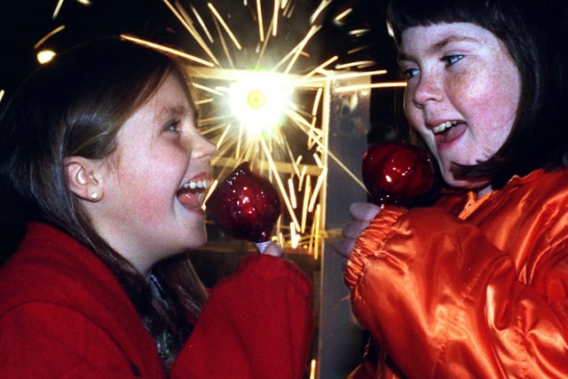 Jade Cahoon, left, and Natalie Howard, of 1st Brookfield Brownies, enjoy their toffee apples and fireworks at the Brownie pack Bonfire party