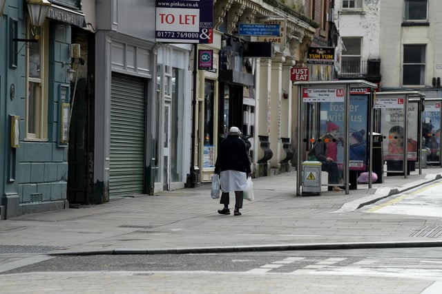 A lone shopper makes his way through the empty streets of Preston