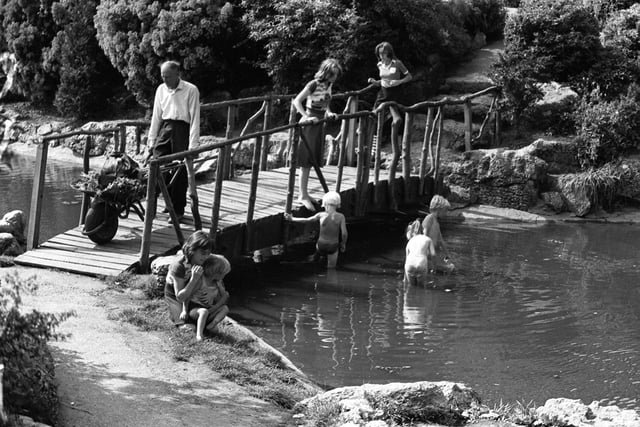 Girls and boys make the most of the hot weather, bathing in water in the Japanese Gardens on Avenham Park, Preston