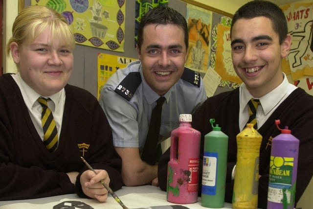 PC Andy Halsall with pupils Vicki Ainsworth, 14, and James Bozzato, 14, at Christ the King High School, Preston, preparing for a poster competition